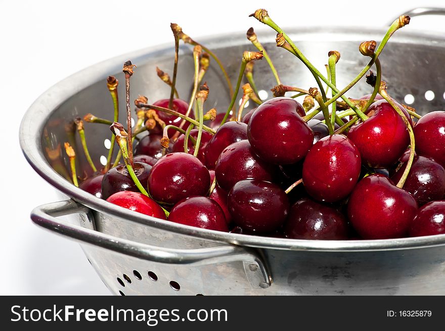 Close-up of colander filled with freshly picked red cherries. Close-up of colander filled with freshly picked red cherries