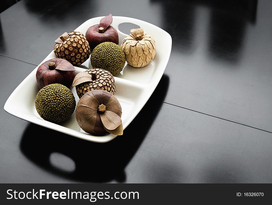 Wooden display fruit sit in a white bowl. Wooden display fruit sit in a white bowl
