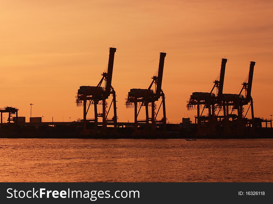 Port warehouse with cargoes and containers at sunrise