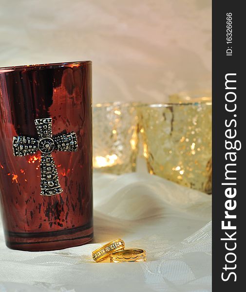 Wedding rings candles and a maroon candle with silver cross. Wedding rings candles and a maroon candle with silver cross