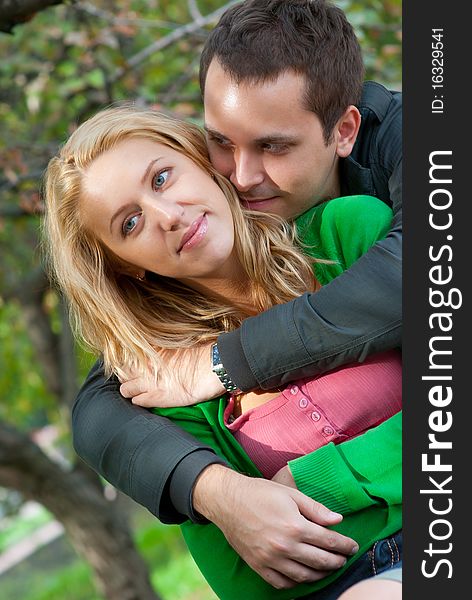 Beautiful young couple embracing in a park