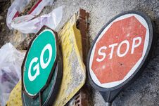 Stop And Go Signs Lying On Street Stock Photo