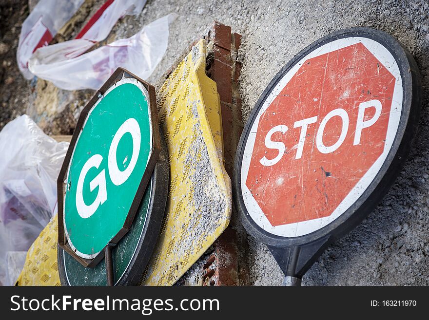 Stop and go signs lying on street