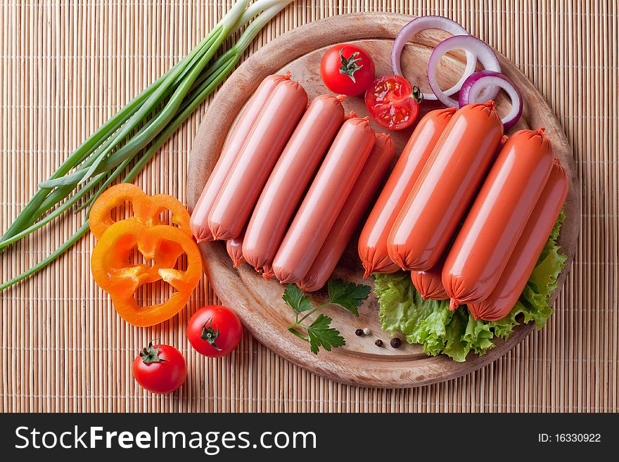 Boiled sausage, on a wooden cutting board.