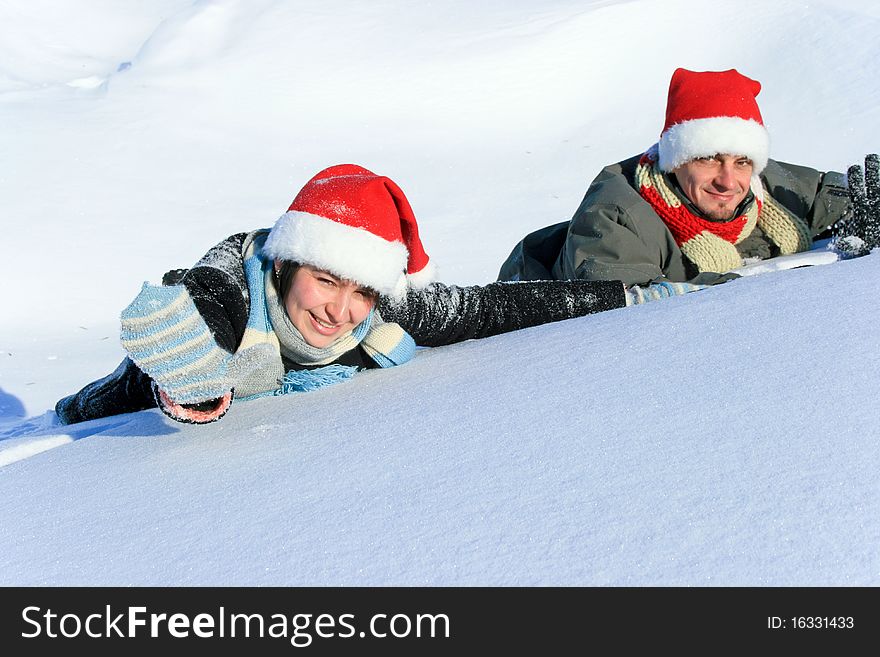 Caucasian woman and man laying on the snow