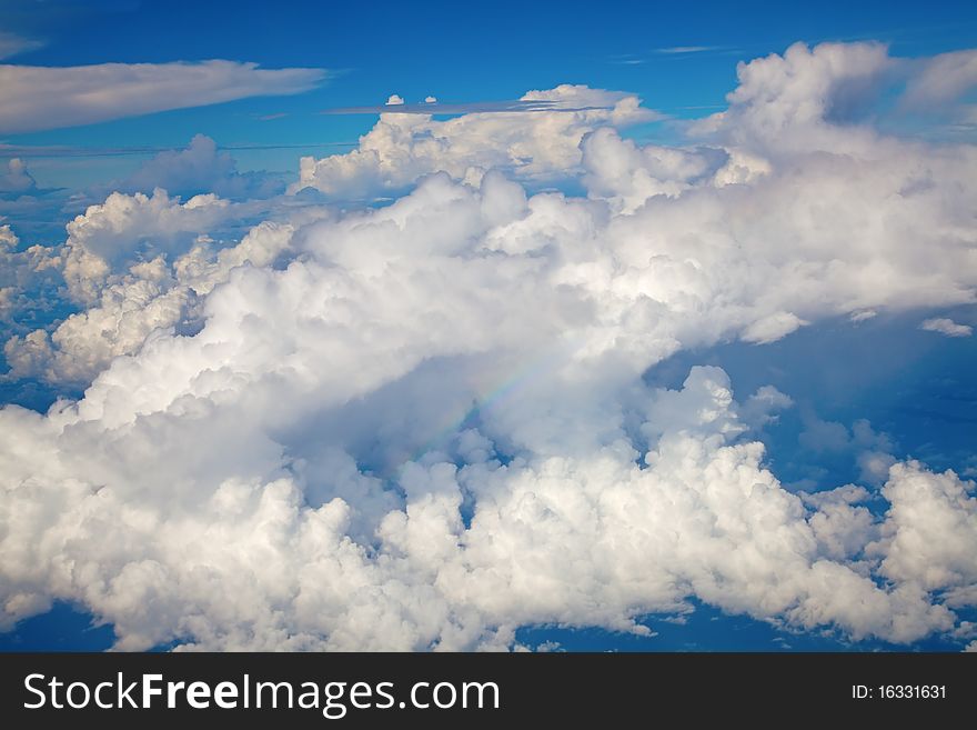 Beautiful cloudscape with fluffy cirrus clouds and rainbow