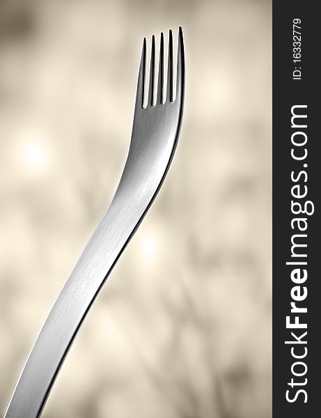 Designer fork in front of light background.