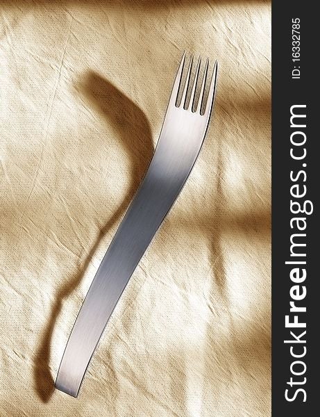 Designer fork in front of light background.