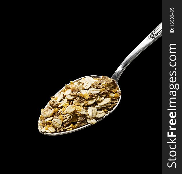 Spoon of muesli (clipping path) on black background