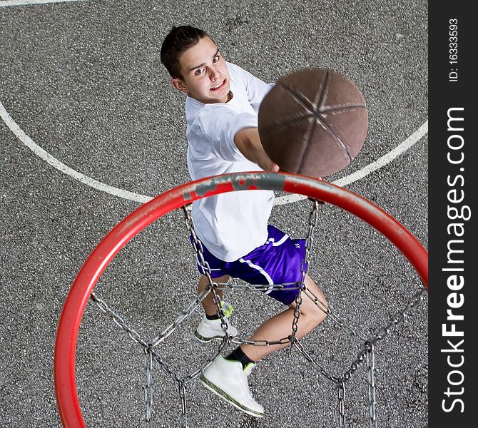 Young basketball player on the street going to the hoop. Great angle from above. Young basketball player on the street going to the hoop. Great angle from above.