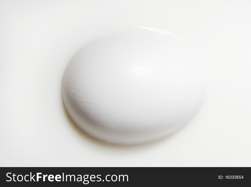 Egg is half drowned in milk. white egg in white milk. white colors. Egg is half drowned in milk. white egg in white milk. white colors.