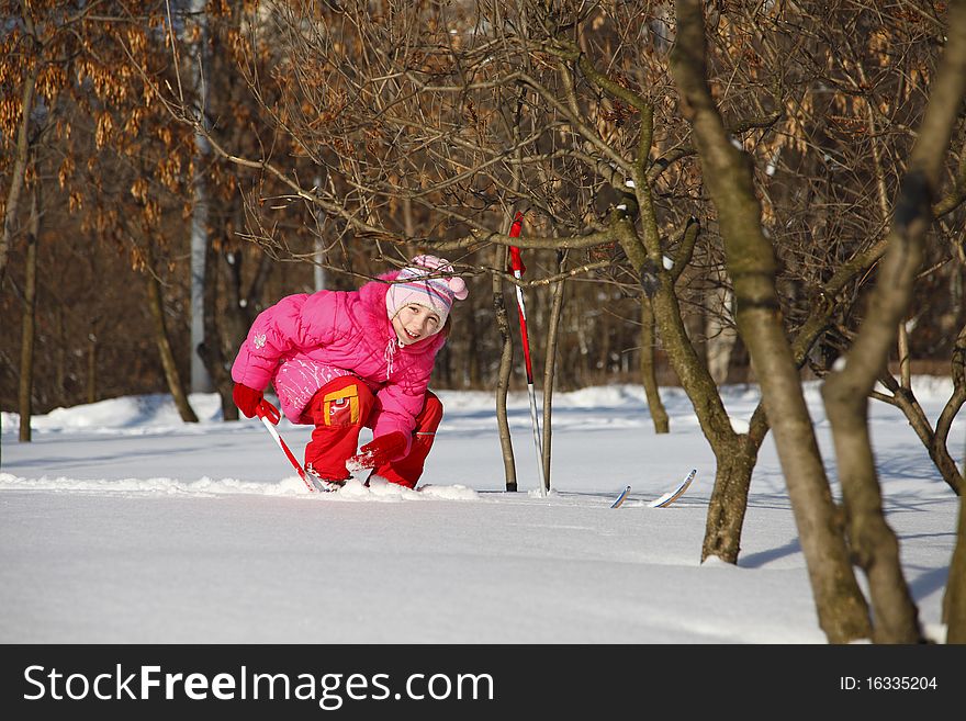 The little girl in a crimson suit on skis. The little girl in a crimson suit on skis