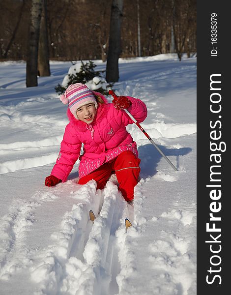 The little girl in a crimson suit on skis. The little girl in a crimson suit on skis