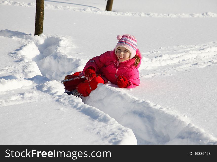 The little girl in a crimson suit on skis. The little girl in a crimson suit on skis