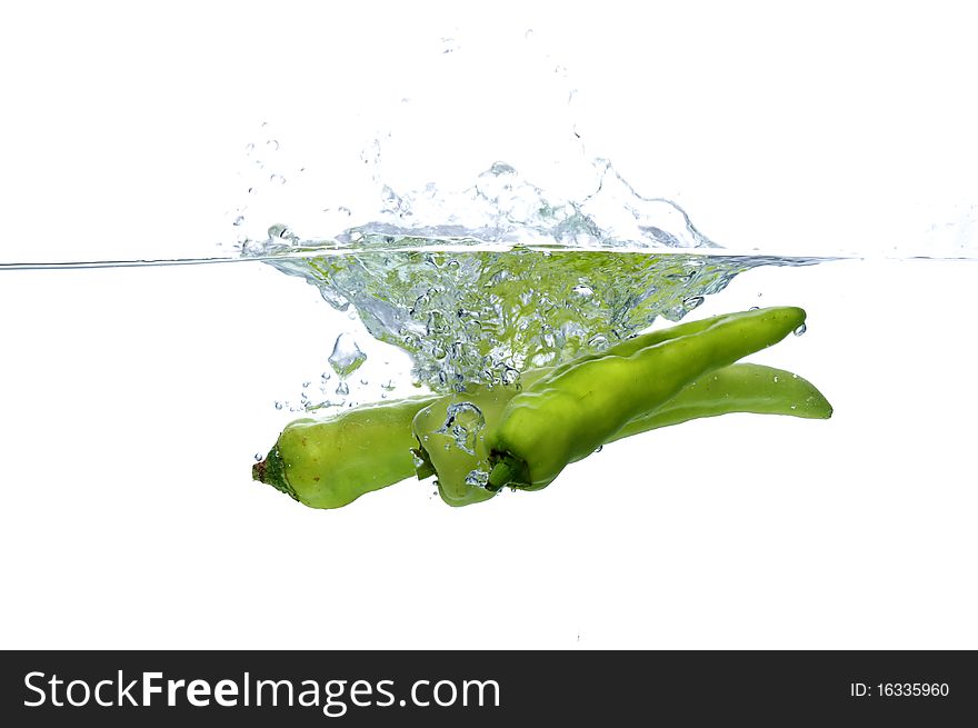 Green chilli thrown in water with white background. Green chilli thrown in water with white background