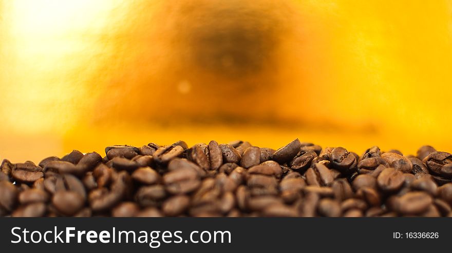 Brown coffee beans on the gold background