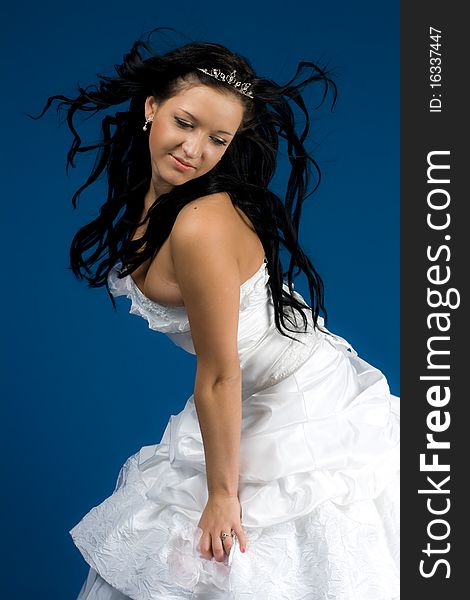 Portrait of beautiful happy bride in a wedding dress on blue background studio shot. Portrait of beautiful happy bride in a wedding dress on blue background studio shot