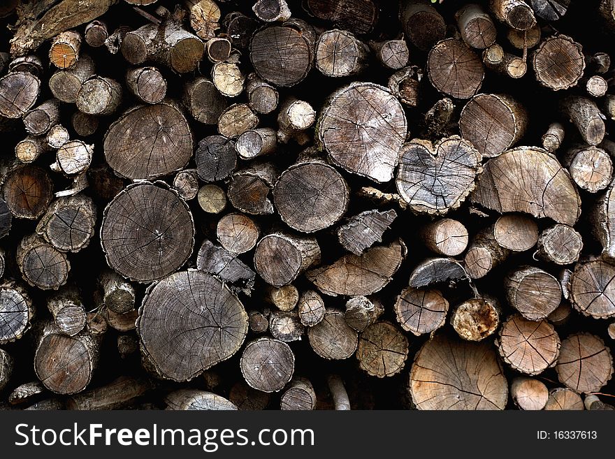 Chopped firewood background with a heart shape between