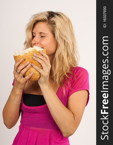 Beautiful brunette girl eating a bread  isolated on the white background. Beautiful brunette girl eating a bread  isolated on the white background