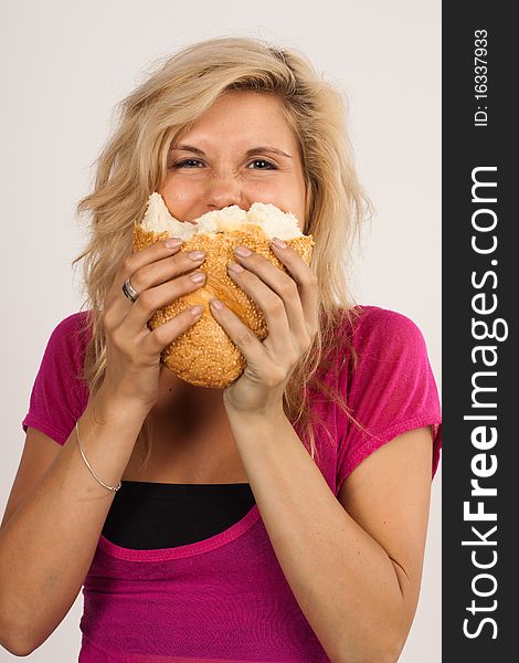 Beautiful brunette girl eating a bread isolated on the white background. Beautiful brunette girl eating a bread isolated on the white background