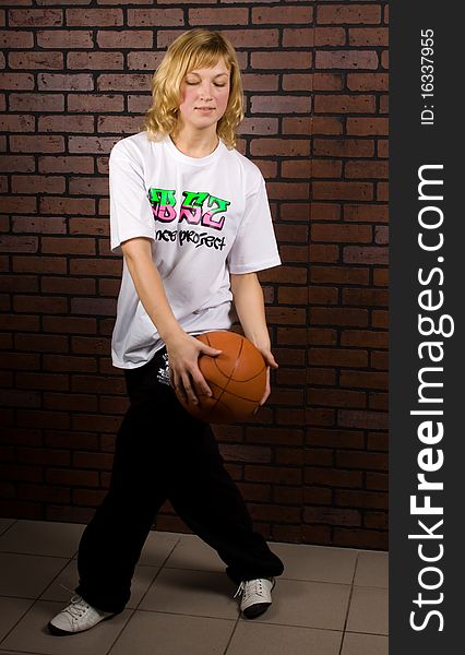 Beautiful stylish girl dancing hip-hop isolated on a brick background. Beautiful stylish girl dancing hip-hop isolated on a brick background