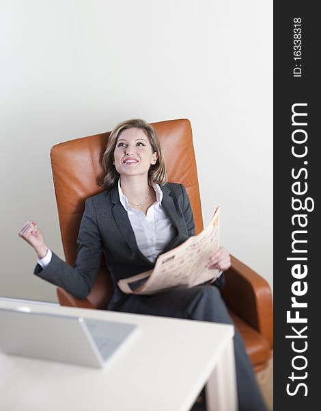 Business woman reading newspaper in the office