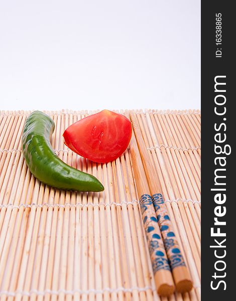 Peppers, tomatoes, sticks at white background