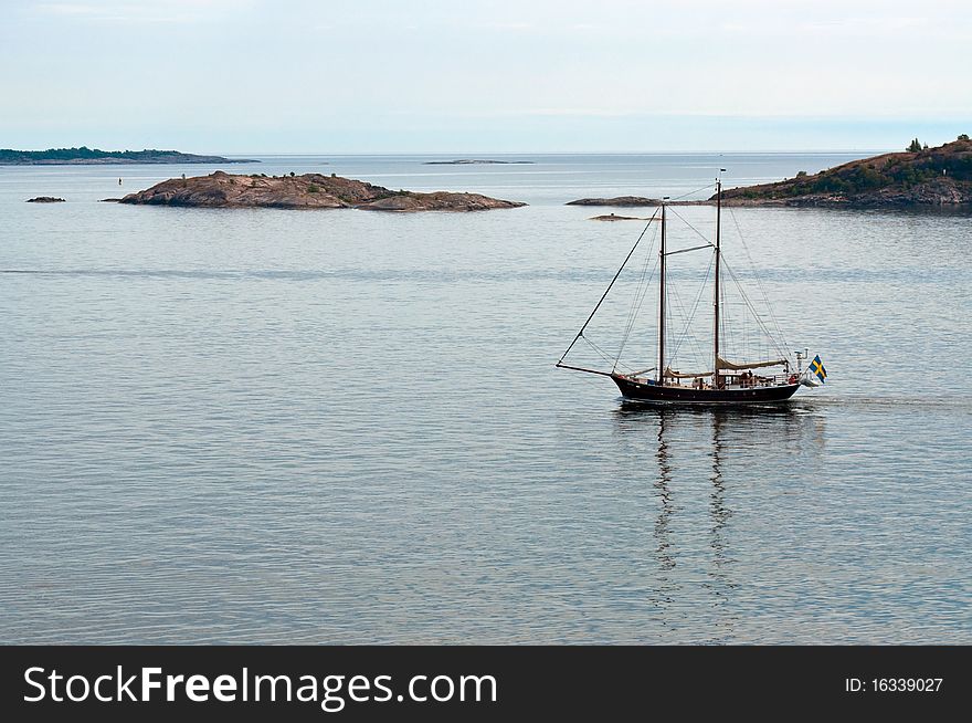 Two-masted ship at sea on the background of the islands