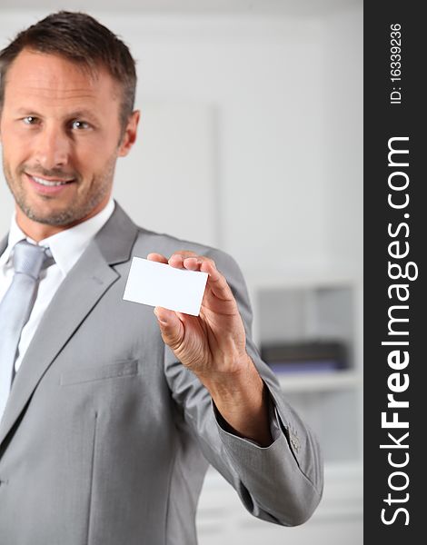 Businessman holding white business card. Businessman holding white business card