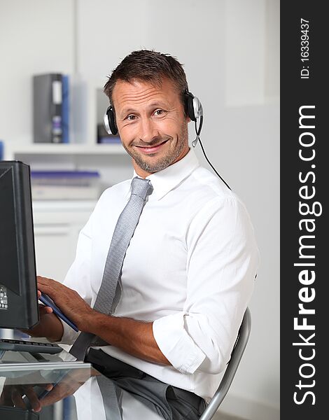 Closeup of businessman in the office with headphones. Closeup of businessman in the office with headphones