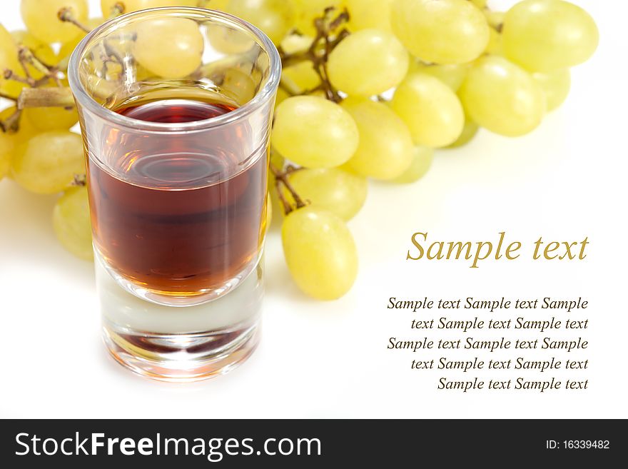 Alcoholic drink in tumbler and grapes