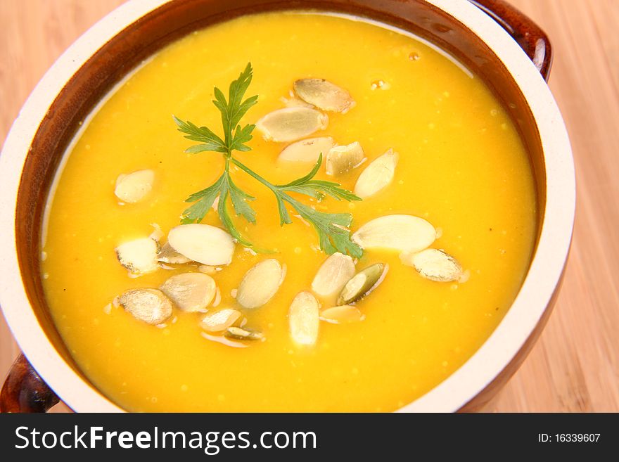 Bowl of pumpkin soup on wooden background