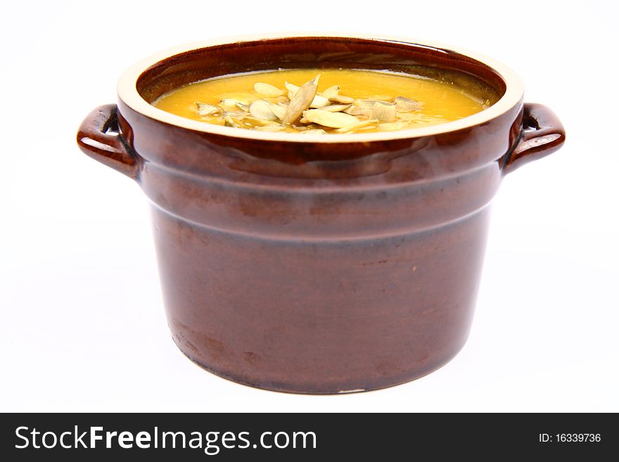 Bowl of pumpkin soup on white background