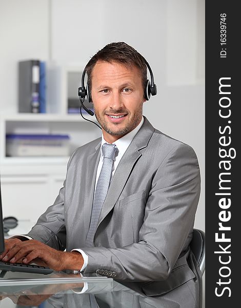 Closeup of businessman in the office with headphones. Closeup of businessman in the office with headphones