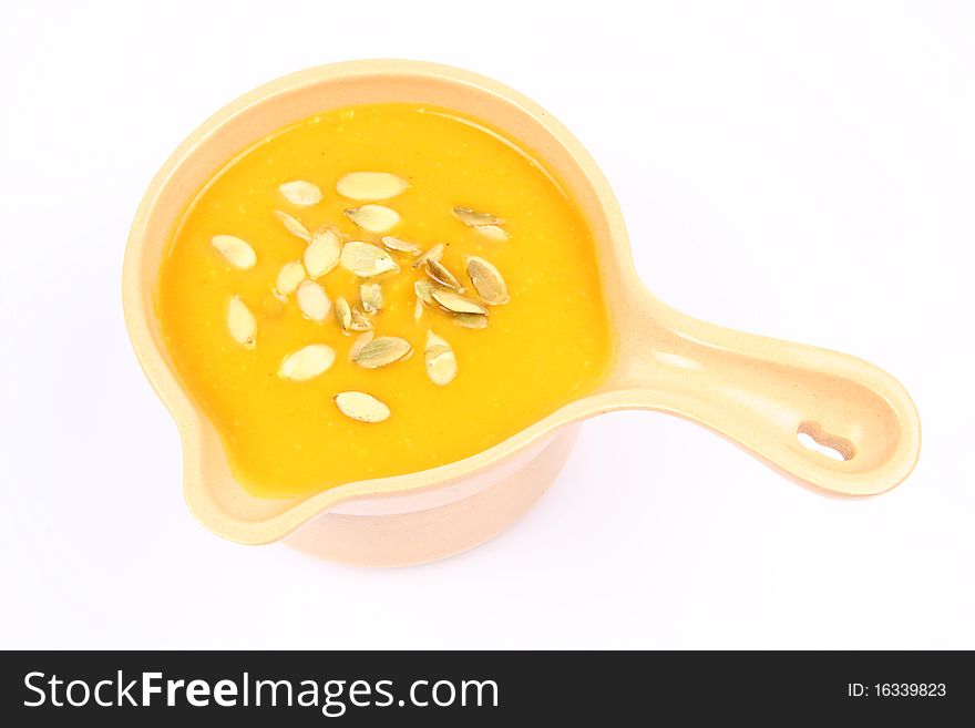 Bowl of pumpkin soup on white background