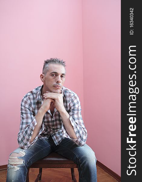 Man in checkered shirt keeps his hands folded