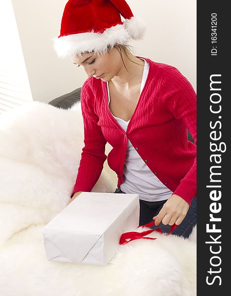 Young woman prepares gift box to Christmas with red ribbon. Young woman prepares gift box to Christmas with red ribbon