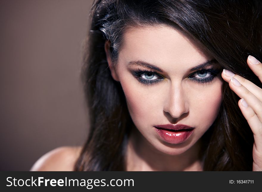Portrait of beautiful woman looking at you, isolated on brown with copyspace