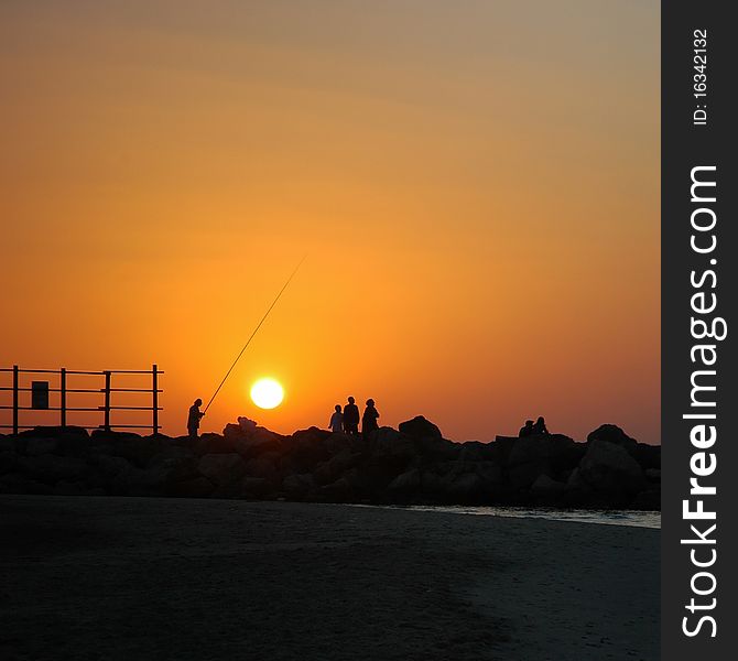 Fisherman and few other persons on city beach at sunset, Tel Aviv, Israel. Fisherman and few other persons on city beach at sunset, Tel Aviv, Israel