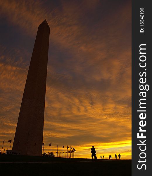 Washington monument at dawn with the flag circle around it and a beautiful sky