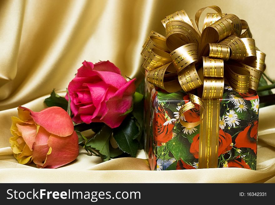 Gift box with flowers on silk background