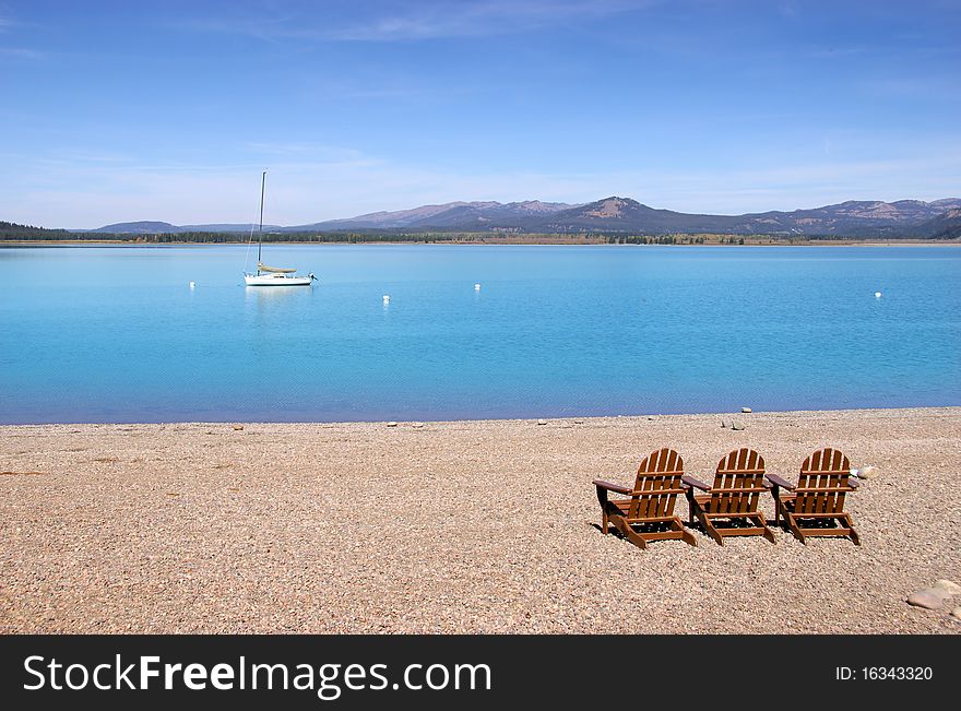 Three wooden chairs by the Jackson lake in Wyoming. Three wooden chairs by the Jackson lake in Wyoming