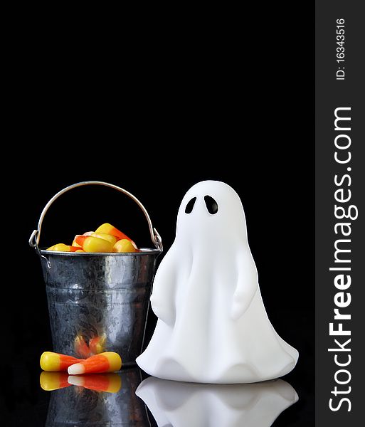 The perfect ghost with a bucket of candy corn and reflection