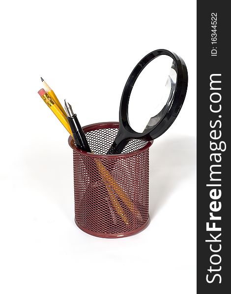 A pencil cup with pencils, fountain pen and a magnifying glass