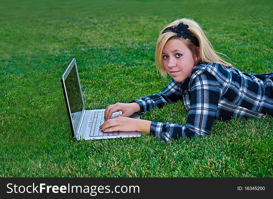 Attractive teenage girl with a laptop outdoors