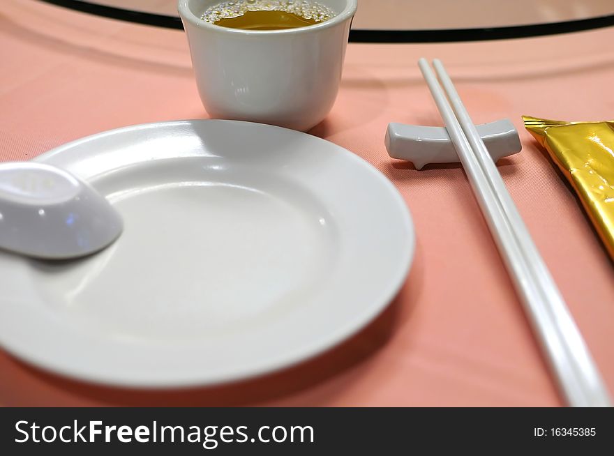 Table layout in a Chinese restaurant or hotel with plates and utensils. Suitable for generic concepts such as food and beverage, dining and food catering services. Table layout in a Chinese restaurant or hotel with plates and utensils. Suitable for generic concepts such as food and beverage, dining and food catering services