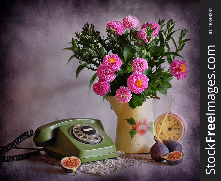 Still life with a green telephone, pink flowers, clock and fig. Still life with a green telephone, pink flowers, clock and fig