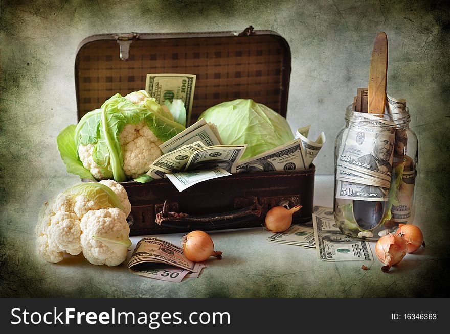 A cabbage and dollars are in a suitcase
