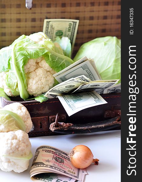 A cabbage and dollars are in a suitcase