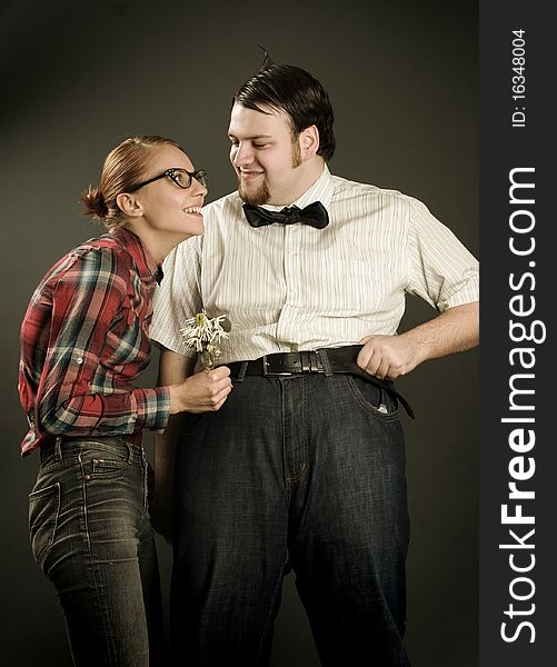 Eccentric young couple on dark background